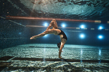 girl doing synchronized swimming in the pool advertising underwater photography