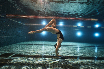 girl doing synchronized swimming in the pool advertising underwater photography - obrazy, fototapety, plakaty
