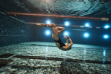 girl doing synchronized swimming in the pool advertising underwater photography