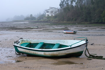 Fishing boats in the Villaviciosa estuary in a foggy day. Asturias, Spain.