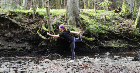 Yoga in nature. Girl in middle of forest conducts a retreat for herself. Individual practice in unity with nature. Solopractic in meditation and Vedic exercises. Forests of the Carpathians, Ukraine