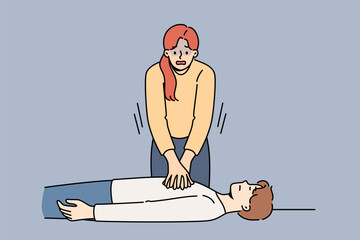 Woman nervous, giving heart massage to man fainted, pressing on chest muscles. Training in first aid and rescue of person with sudden heart failure or impaired cardio functions of body