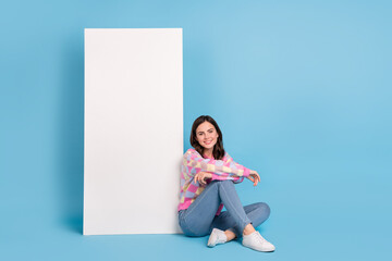 Full length photo of young pretty woman good mood sit floor advert isolated over blue color background