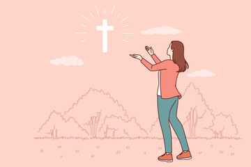 Catholic woman looks at cross glowing in sky, praying to god for help in finding right path. Sign from god in form of christian crucifix and believing girl looking in surprise at miracle