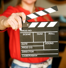 Woman's hands holding a clapperboard. A young girl holding a movie clapboard in front of a red ...