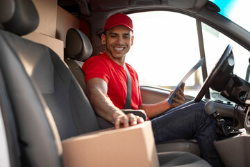 Courier delivery concept. European man driver driving delivery car and smiling at camera
