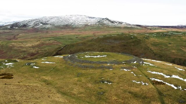 Brough Law prehistoric Iron Age hillfort. N.W. over River Breamish valley near Ingram, Cheviot Hills, Northumberland, England. Video fly in from S.E.