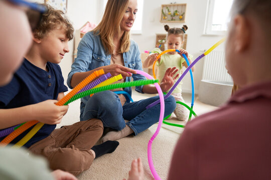 Teacher and children doing sensory exercises with pipes
