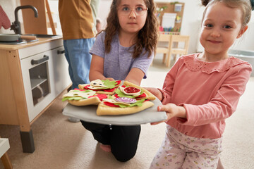 Two child girls playing together in the kindergarten