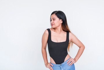 Confident young Asian woman in black bodysuit posing on white background
