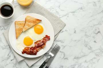 Delicious breakfast with sunny side up eggs served on white marble table, flat lay. Space for text