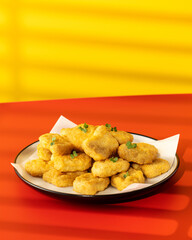 Delicious golden chicken nuggets on a plate on the table. Fast food, menu.