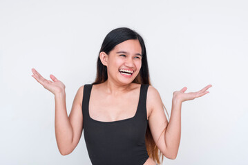Joyful Asian woman in black bodysuit laughing with arms raised, isolated on white