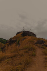 A mountain range with a foggy sky and a few people on the top
