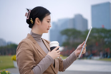 Modern Young Woman Using Tablet in Urban Park