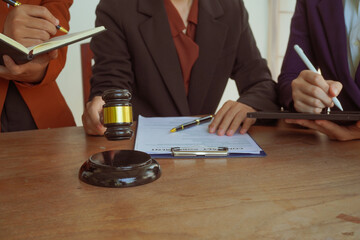 A group of lawyers and clients engage in a professional meeting at a law office, discussing...