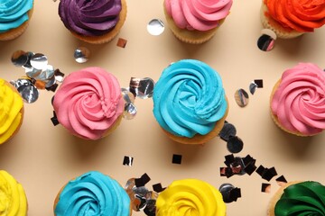 Delicious cupcakes with bright cream and confetti on beige background, flat lay