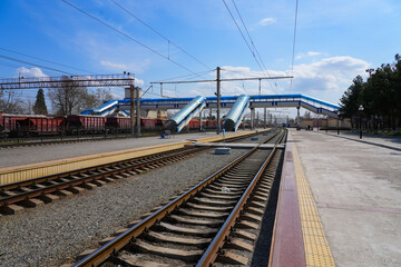 Fototapeta premium Pedestrian footbridge passing over the railway tracks at Samarkand Train Station in Uzbekistan, Central Asia