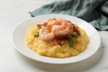 Plate with fresh tasty shrimps, bacon, grits and green onion on white marble table