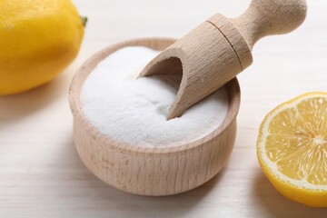Baking soda and lemons on white wooden table, closeup