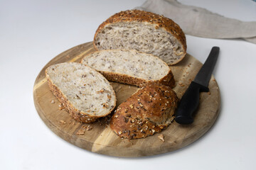 Round freshly oat baked bread sliced on a cutting board.
