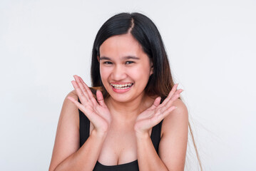 Portrait of a cheerful young Asian woman in a black bodysuit, posing playfully on a white background