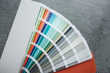 Rainbow catalog of paints with a various color palette on grey desk