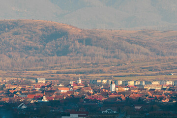 A vibrant cityscape nestled against the grandeur of a towering mountain in the background