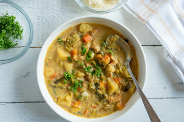 Potato soup with leek and turkey meat on a plate