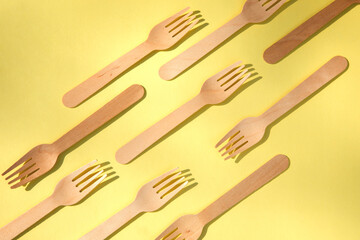 Fototapeta premium A wooden cutlery on a yellow background. Eco friendly, zero waste concept. Top view