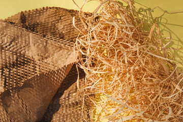 Packaging of eco-materials. Packaging paper and decorative box filler, dry hay on a yellow background. Concept saving the planet from undetectable debris. Top view