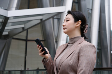 Confident Businesswoman Using Smartphone in the City