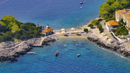 AERIAL: Tourists are enjoying the summer activities on the shores of Hvar island - obrazy, fototapety, plakaty