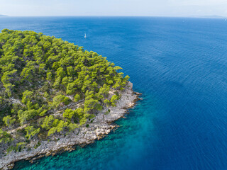 AERIAL: Scenic drone shot of a sailboat sailing near picturesque Hvar island.