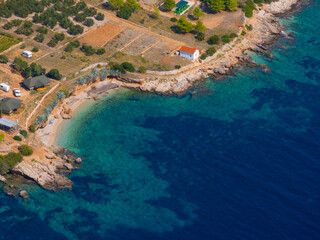 AERIAL: Few camping vehicles and lone house face the turquoise Adriatic sea.
