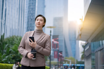 Professional Woman with Smartphone in Urban Setting