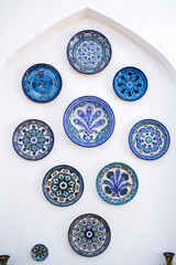 traditional east Uzbek ceramic plates hand-painted on wall at the oriental tableware shop in Uzbekistan