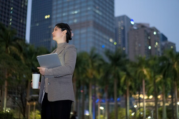 Confident Businesswoman Overlooking Cityscape at Twilight