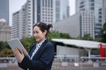 Professional Woman Engaged with Tablet in Cityscape