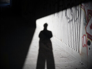L'ombre d'un homme dans un tunnel avec des graffitis sur les murs