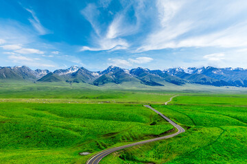 Beautiful grassland natural landscape in Xinjiang, China. Green meadow and mountain landscape in summer.