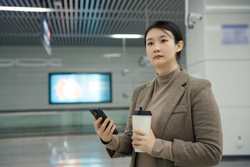 Professional Young Woman on the Go with Smartphone and Coffee