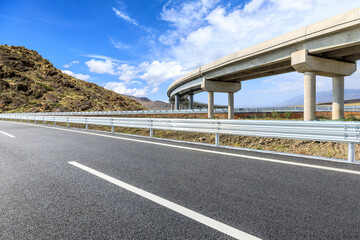 Asphalt highway road and bridge with mountain nature landscape on sunny day