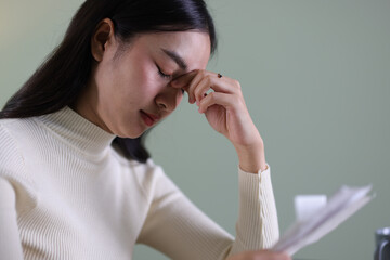 Woman with financial problems at home. Woman is stressed over financial bills and expenses at home.