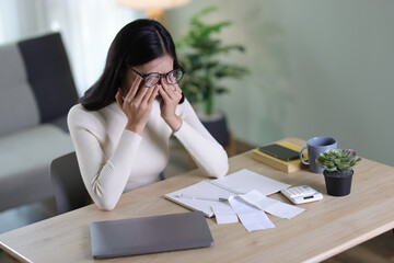 Woman with financial problems at home. Woman is stressed over financial bills and expenses at home.