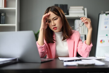 Businesswoman working with laptop in office, she is seriously working, is stressed and tired.