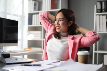 Woman working in office stretching during break to relieve fatigue.