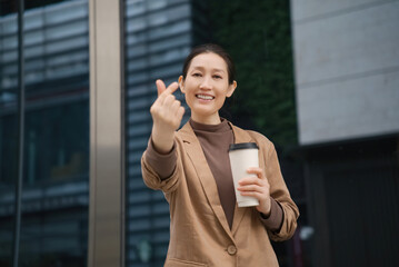 Confident Businesswoman with Coffee Giving Thumbs Up