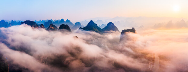 Sea of clouds around mountain peaks at sunrise. Famous karst mountain natural landscape in Guilin,...