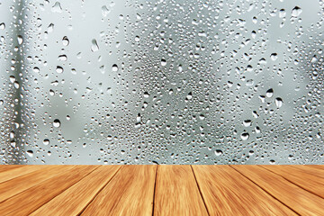 Wooden tabletop on raindrops on clear window - obrazy, fototapety, plakaty